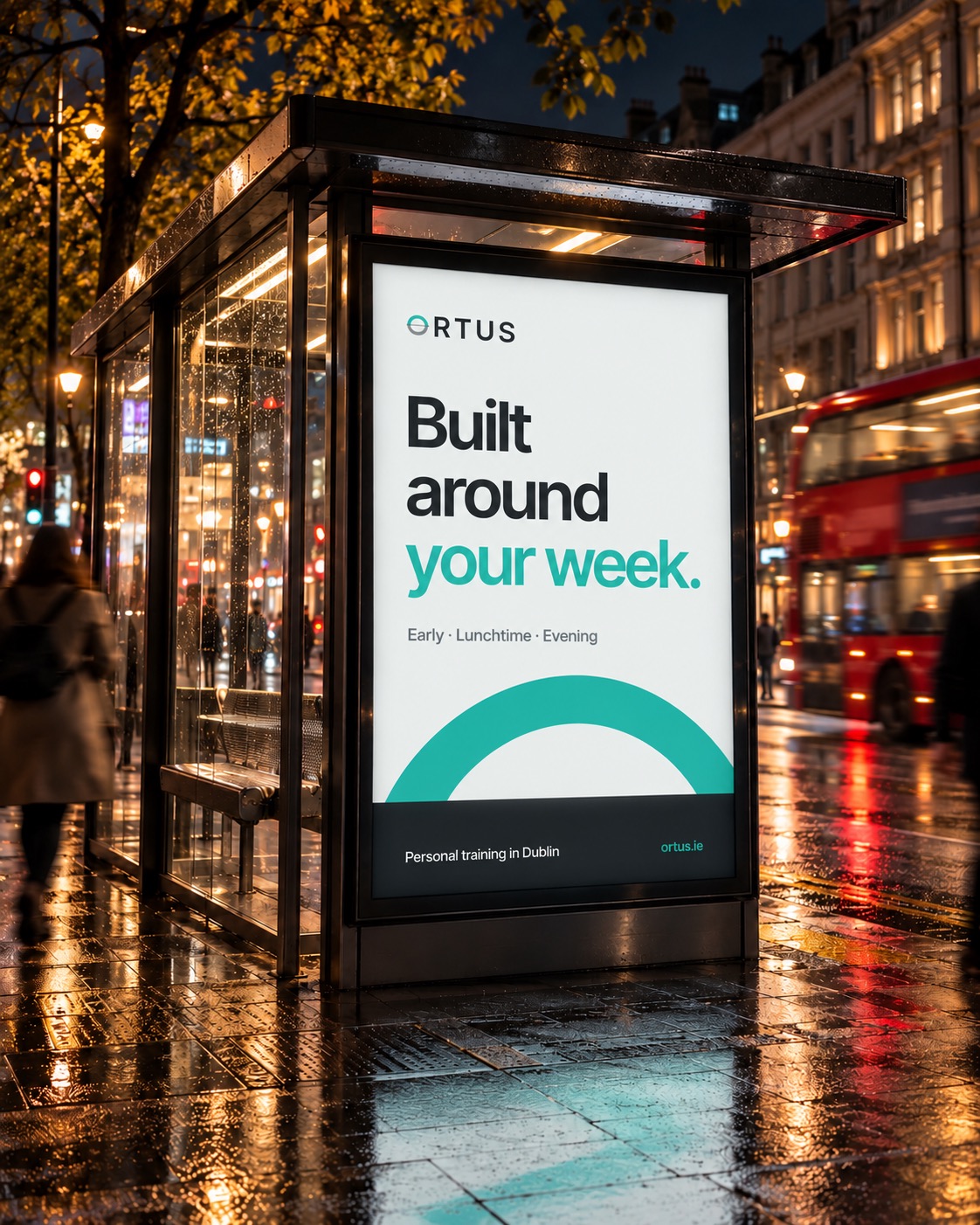 The ORTUS poster "Built around your week." in a bus shelter at night
